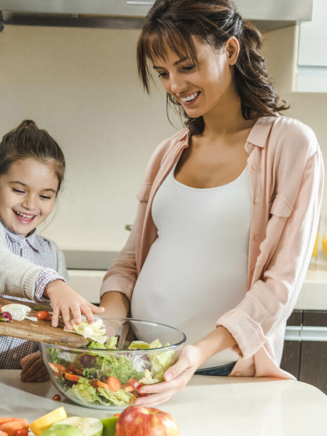 Gestante preparando um prato adequado para sua situação junto de sua família.