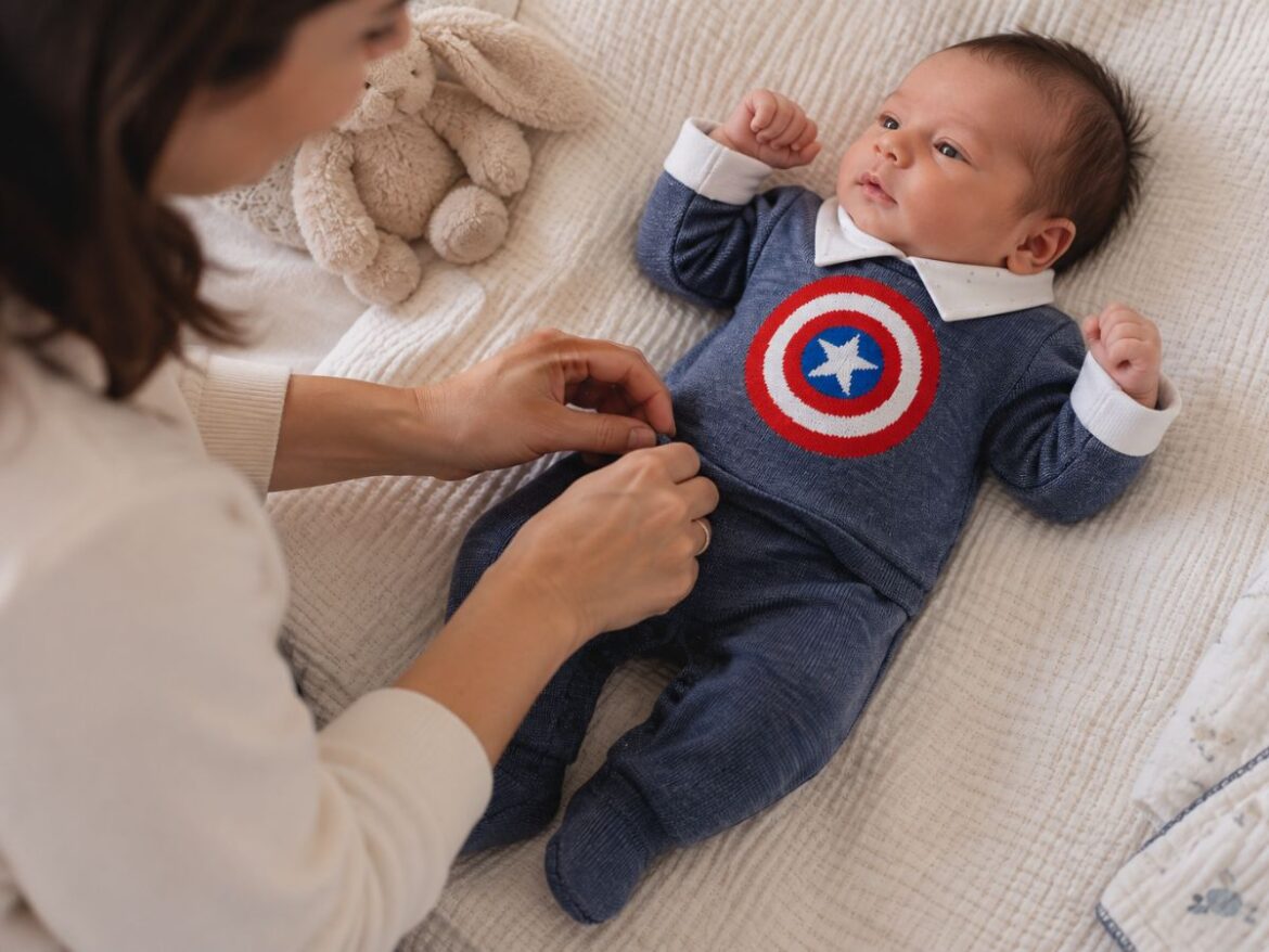 Mãe vestindo seu filho com roupinha do capitão américa