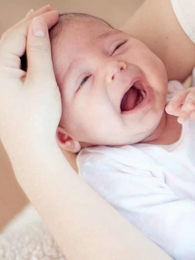 Bebê com cólica chorando emquanto mãe passa mão sobre sua cabeça. bebês transpiram cabeça