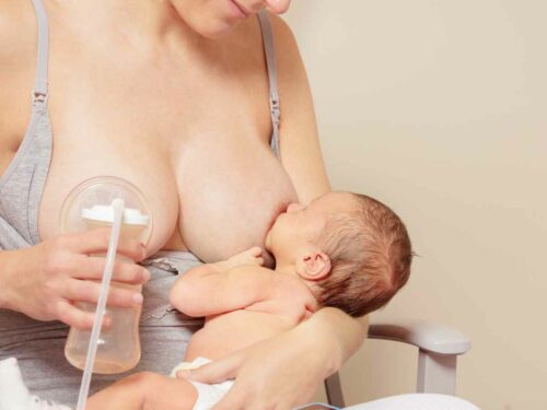 Mulher amamentando recém nascido e bombeando leite para regular a produção e diminuir as dores na mama.