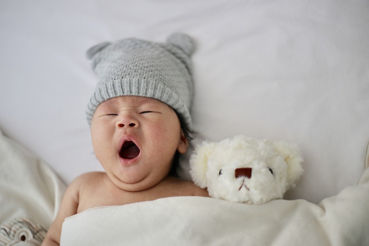 bebê no berço bocejando, acordar o bebê para amamentar é certo?