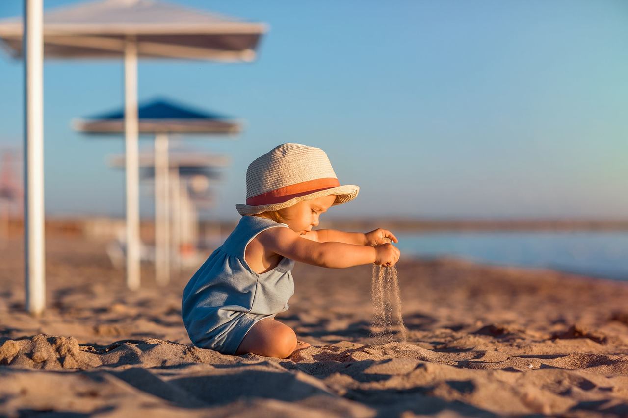 bebe na praia brincando com areia
