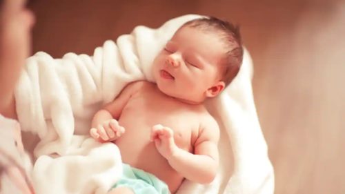 Bebê recem nascido no colo com linguinha para fora, simbolizando nomes de bebes diferentes