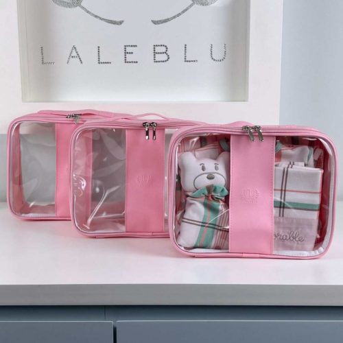 Bolsa kit organizador da marca Laleblu, transparente com detalhes em rosa e zíper. Dentro de uma das bolsas há uma manta para bebê e um ursinho de pelúcia, Ao fundo da imagem, está escrito "Laleblu"