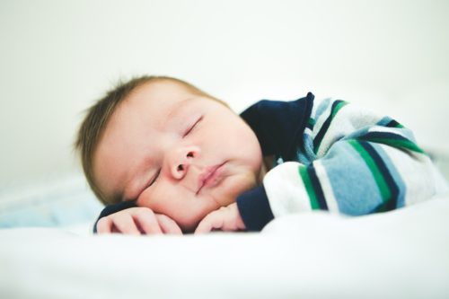 Bebê dormindo agasalhado, simbolizando como saber se o bebê está com frio