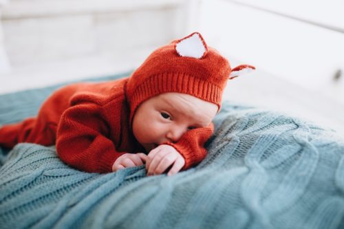 Bebê com roupinha de frio e touca com orelhinhas, simbolizando dúvidas sobre como saber se o bebê está com frio