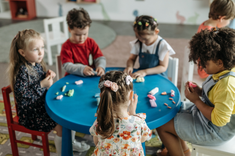 Crianças sentadas em uma mesa brincando