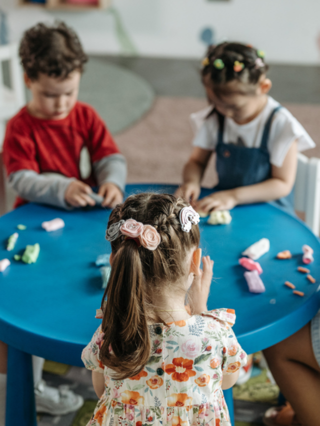 Crianças sentadas em uma mesa brincando