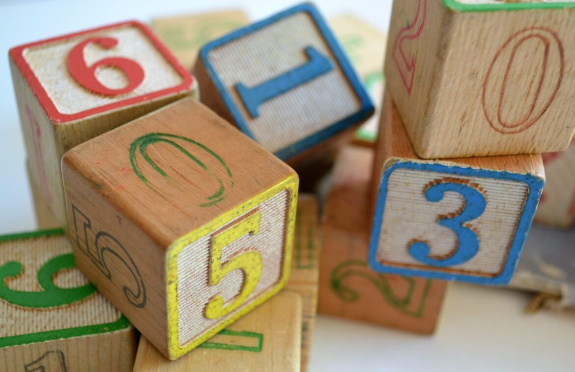 Vários blocos de madeira com detalhes coloridos juntos. Brinquedo por idade