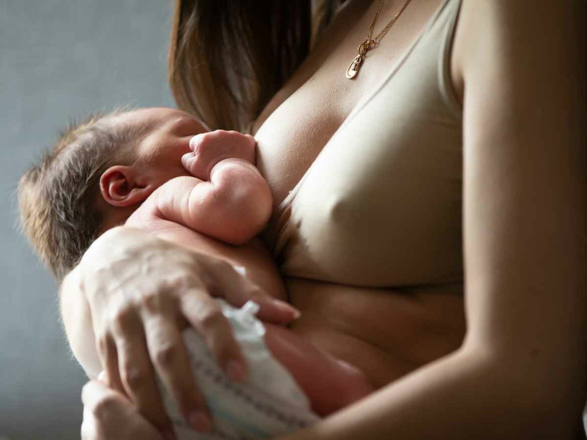 Mulher amamentando seu filho de noite.