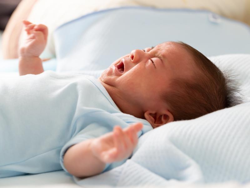 bebê deitado chorando por estar com dor relacionado a cólica