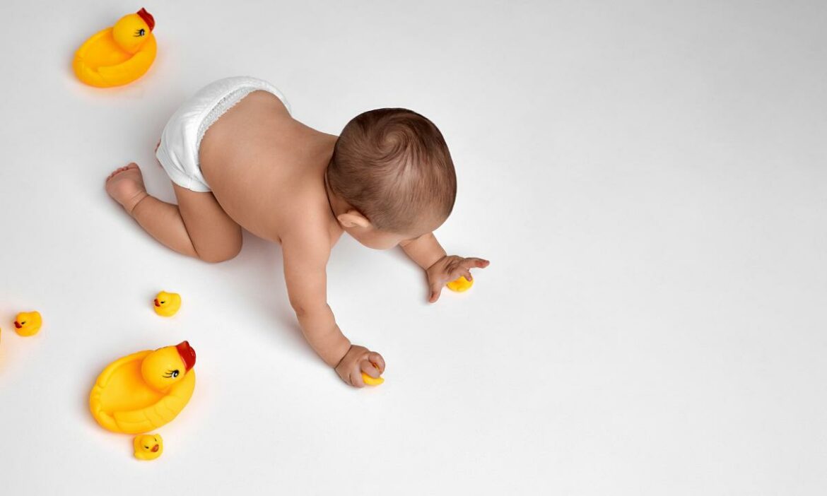 bebê brincando e engatinhando atrás dos patinos de borracha, estimulando a independência do bebê