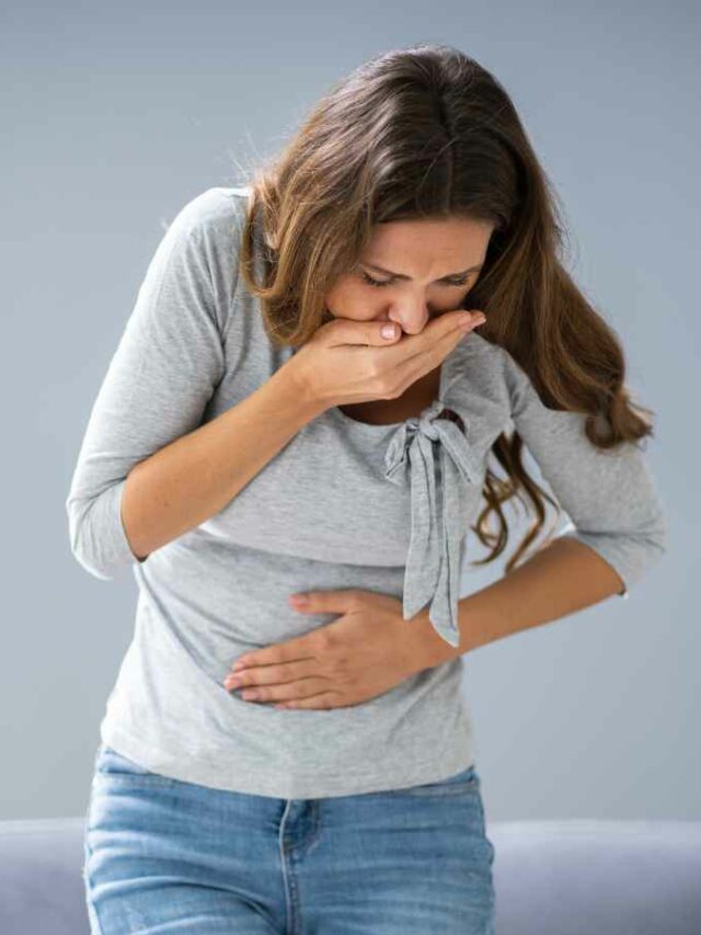 CROPPED: Mulher enjoada após sentir cheiro de comida desagradável, um dos sintomas iniciais da gravidez.