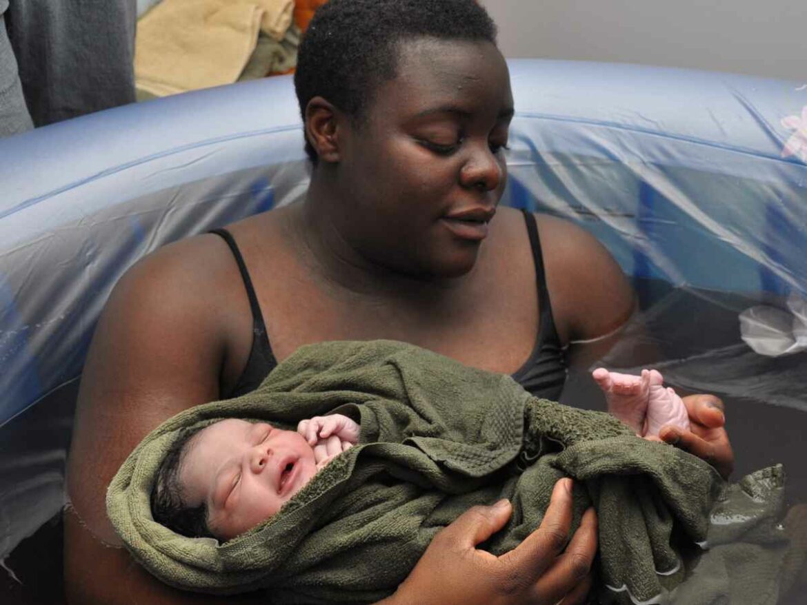 Mulher que deu luz ao seu filho através do parto humanizado em um ambiente acolhedor que respeitava suas escolhas, dentro de uma banheira.