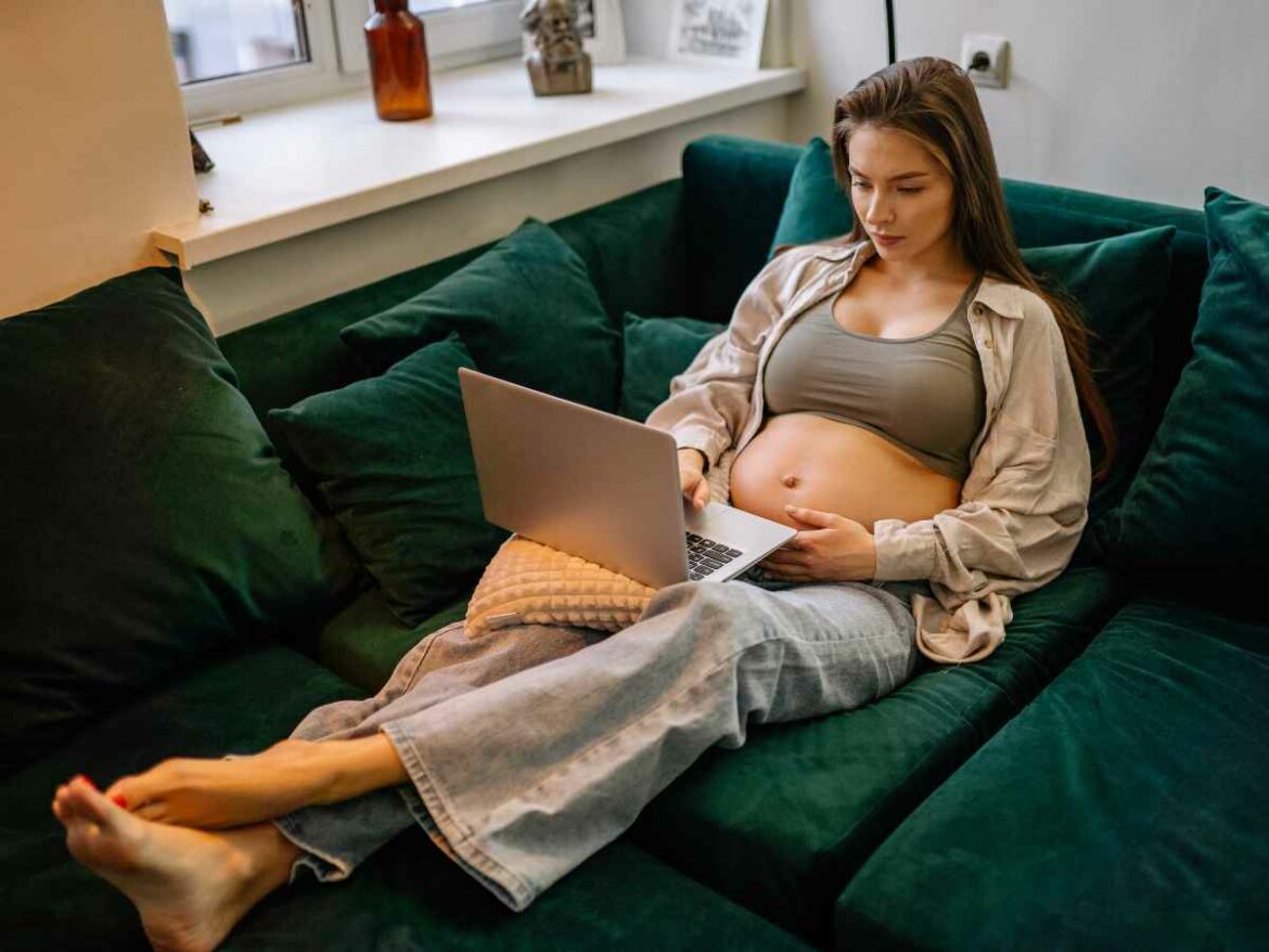 Grávida pesquisando sobre vida intrauterina para garantir que seu bebê possa dormir com tranquilidade dentro do útero.