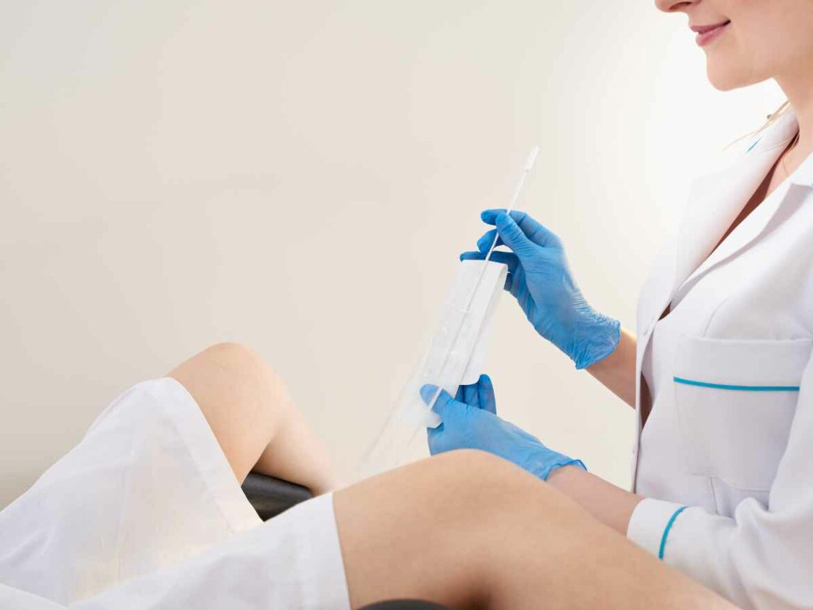 Grávida passando por exame clínico para determinar a causa da sua infecção vaginal.