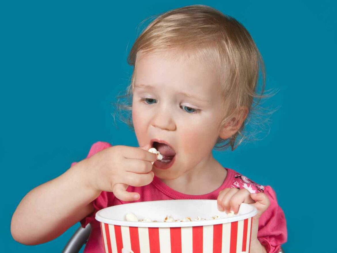 Bebê comendo pipoca de sagu.
