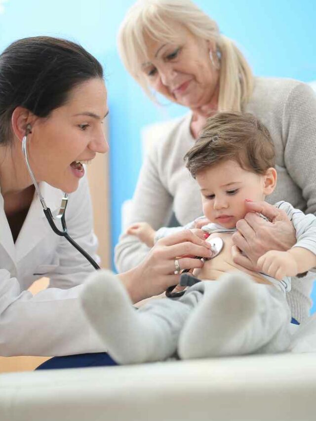 Pediatra examina um bebê com estetoscópio enquanto ele está no colo de uma mulher mais velha, possivelmente a avó.