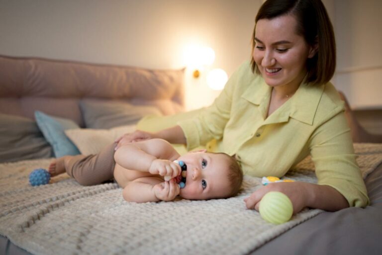 Bebê deitado na cama brincando com sua mãe.