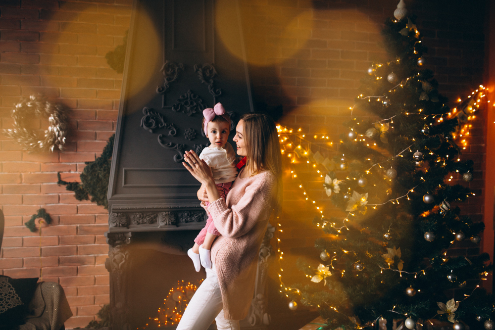Mãe e filha em frente a árvore de Natal com look rosa comemorando o ano novo.