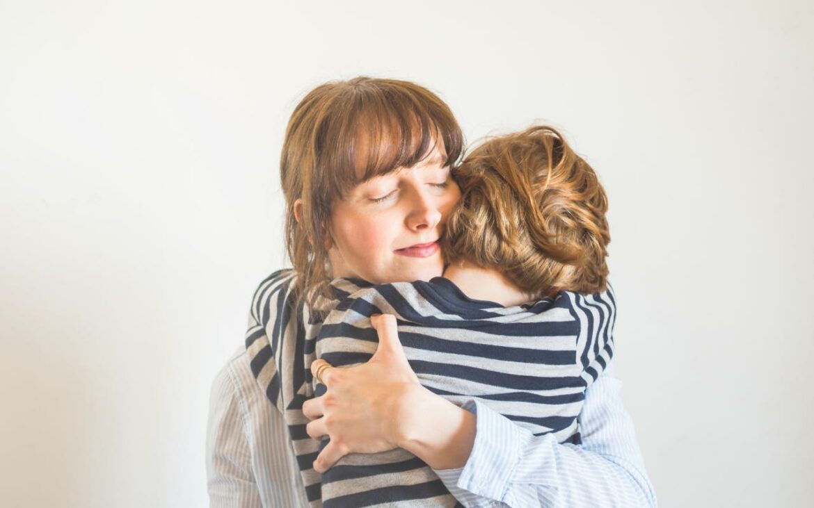 Mãe de menino recebendo abraço do filho.