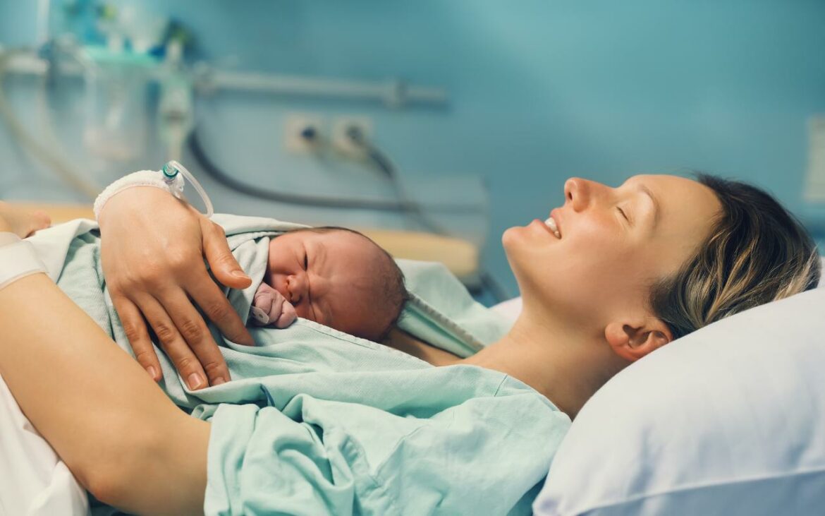 Mãe segurando bebê logo após nascimento por meio de parto normal.