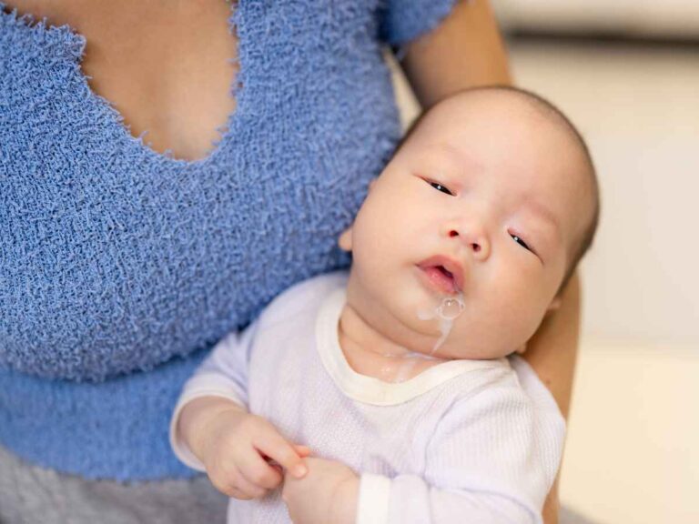 Bebê com refluxo deitado no colo de sua mãe