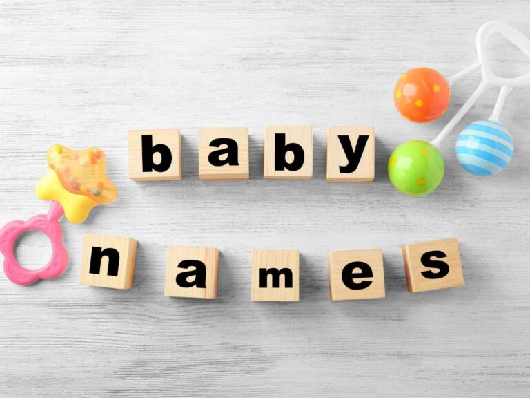 Blocos de madeira formando a frase “baby names” ao lado de brinquedos infantis coloridos