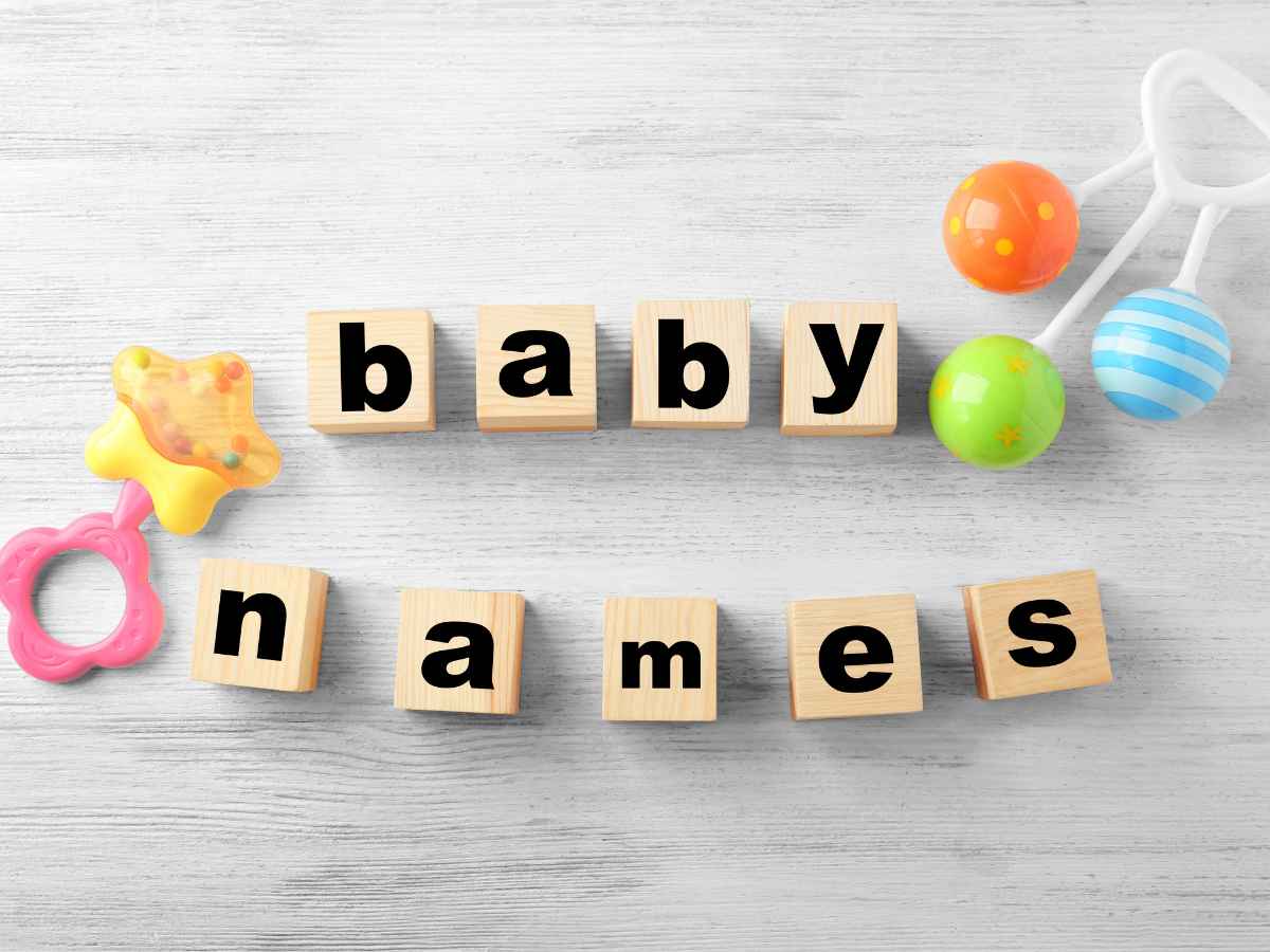 Blocos de madeira formando a frase “baby names” ao lado de brinquedos infantis coloridos