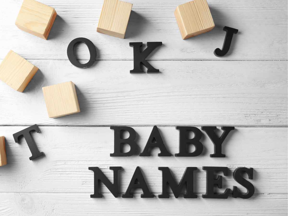 Letras de madeira em preto, organizadas de forma que formam "Baby names"